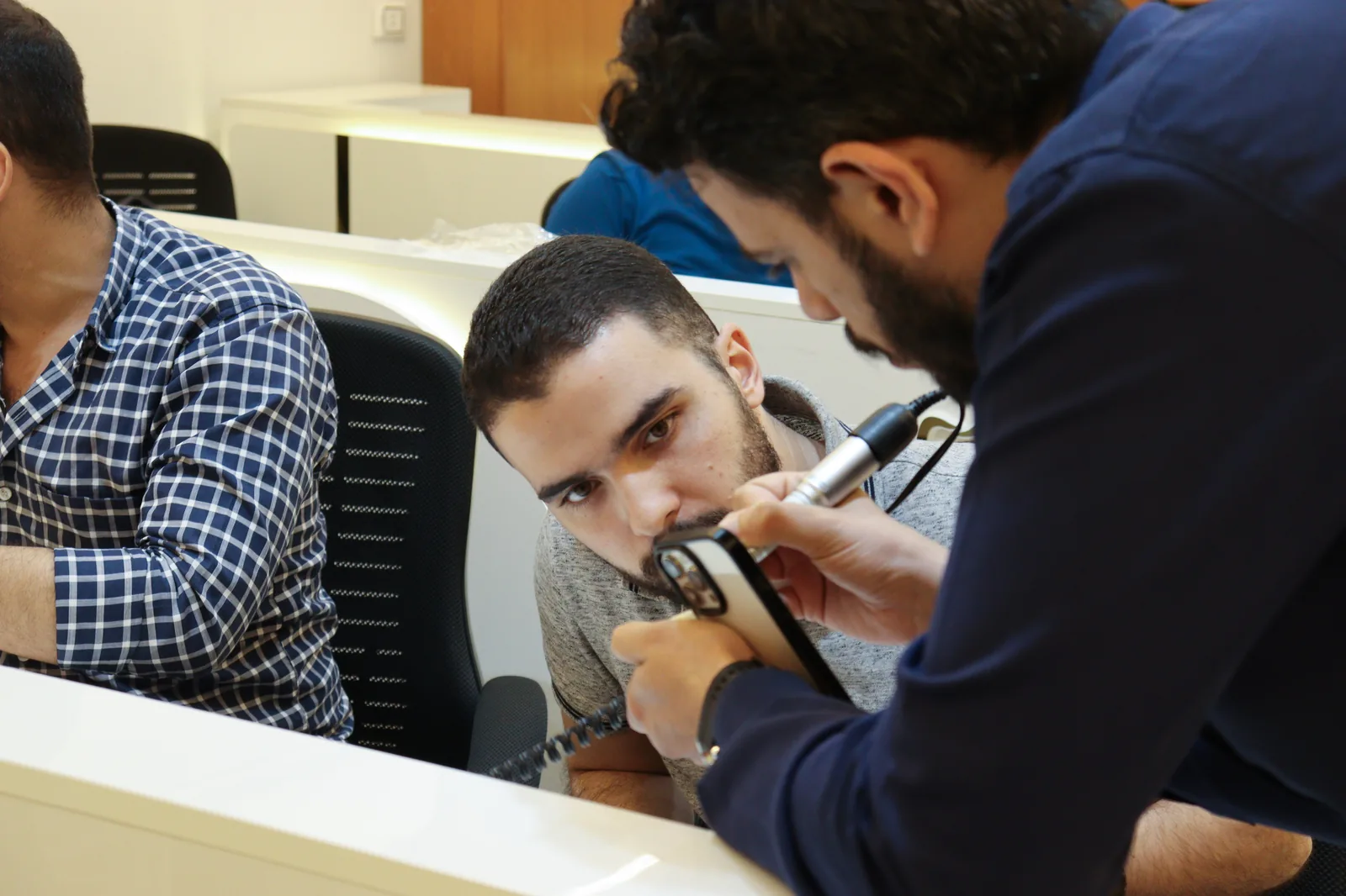 An instructor guiding a participant during a drilling workshop