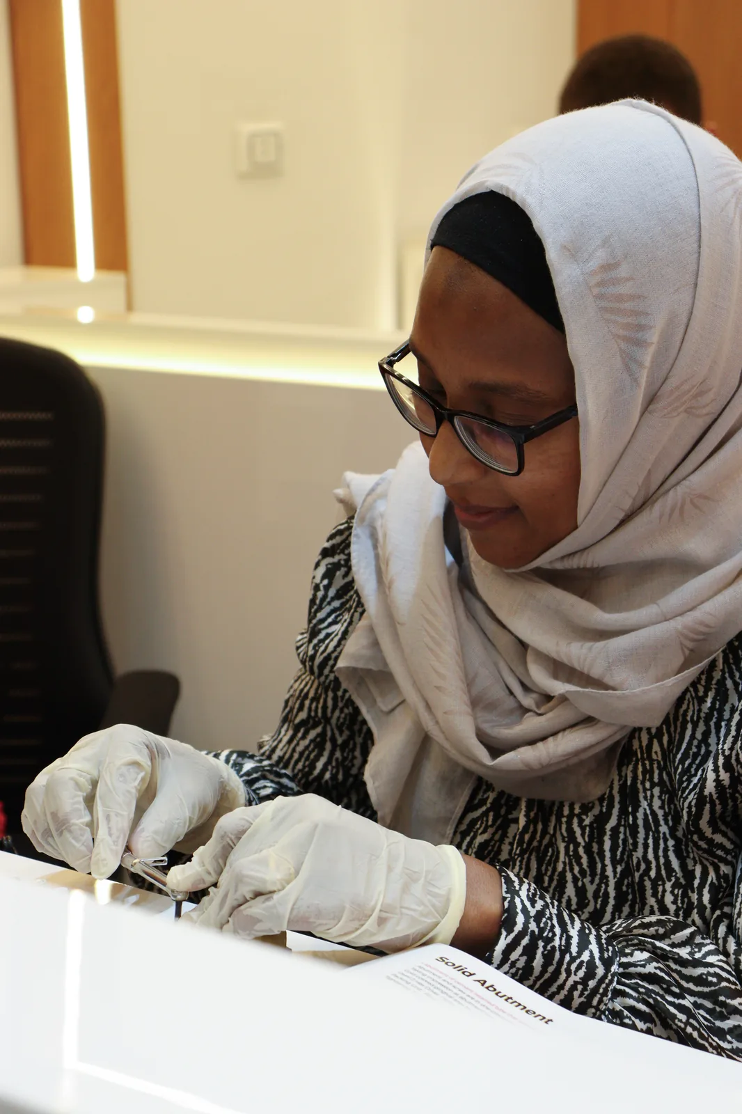 A participant working with a solid abutment during a hands-on prosthetics session