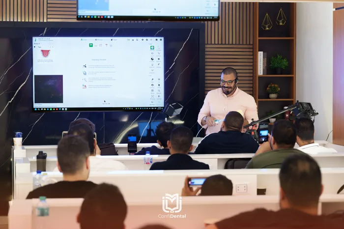 An instructor presenting implant planning software to seated participants