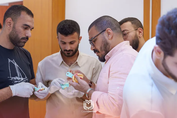 An instructor reviewing implant models with three participants